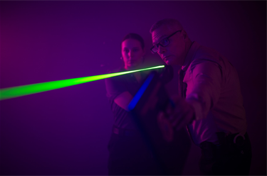 Detective and investigator pointing a laser